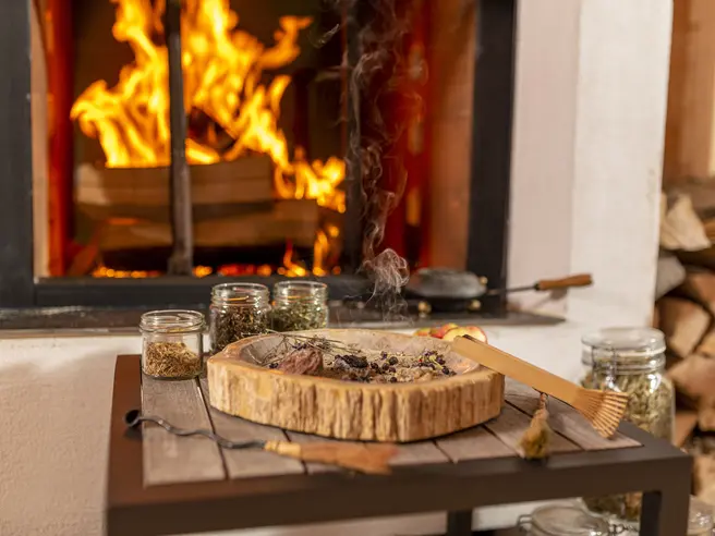 Räucherschale und Kräuter Räucherschale mit Kräutern und Zubehör auf einem Holztisch.
