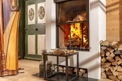 Räuchern am Kamin mit Harfe Räucherwerk vor dem brennenden Kamin im Salettl, daneben eine Harfe.