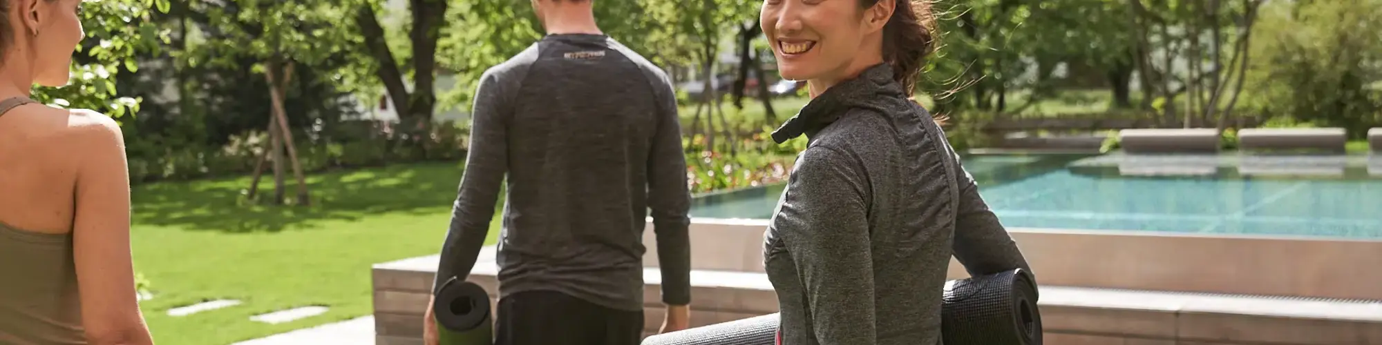 Gäste mit Yogamatten im Garten des MalisGarten Green Spa Hotels.