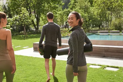 Gäste mit Yogamatten im Garten des MalisGarten Green Spa Hotels.