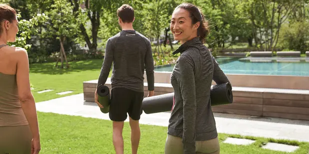 Gäste mit Yogamatten im Garten des MalisGarten Green Spa Hotels.