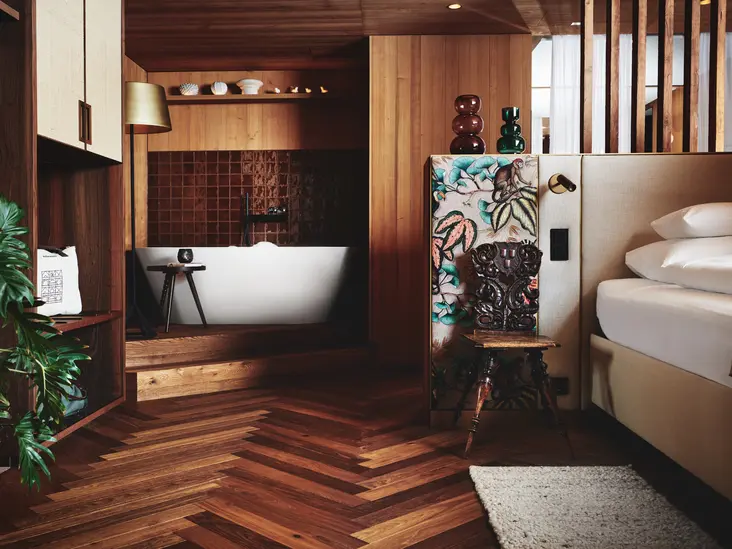 Suite Lavandula mit freistehender Badewanne Gemütliches Schlafzimmer der Suite Lavandula mit freistehender Badewanne und warmem Holzinterieur.